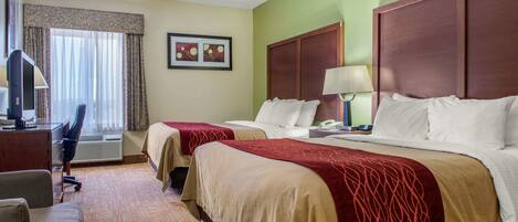 A hotel room with two beds, a desk with a chair, a TV, and a window with curtains.