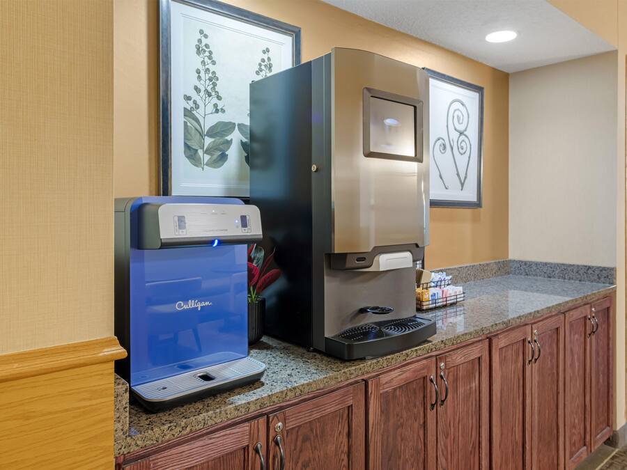A kitchenette with a coffee machine, a water dispenser, and a countertop.