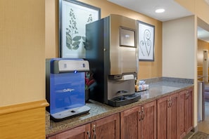 A kitchenette with a coffee machine, a water dispenser, and a countertop. - Best Western Plus Chelsea Hotel (Monticello)