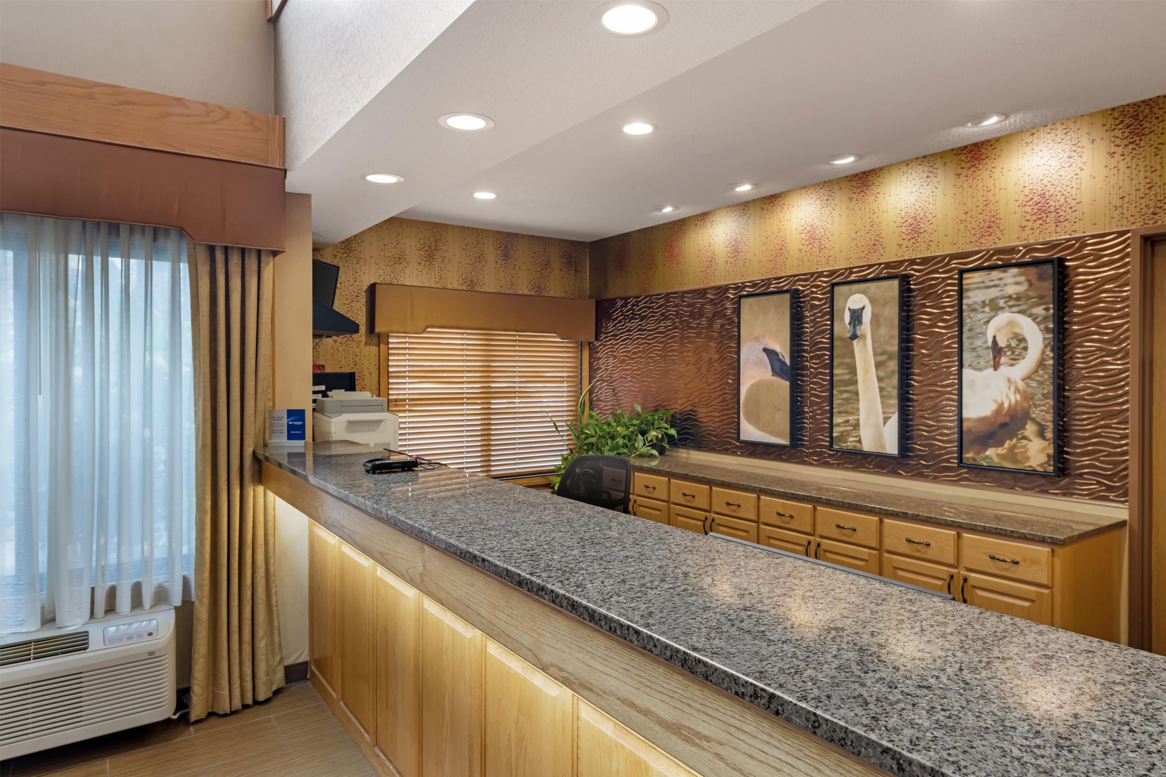 A modern kitchen with granite countertops, wooden cabinets, and a built-in stove.