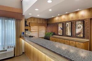 A modern kitchen with granite countertops, wooden cabinets, and a built-in stove. - Best Western Plus Chelsea Hotel (Monticello)