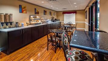 A restaurant with a wooden floor, dark cabinets, and a counter with coffee machines.