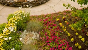 A hotel with a fountain, landscaped garden, and a large building with a sign. - Comfort Inn & Suites Near Burke Mountain (St. Johnsbury)