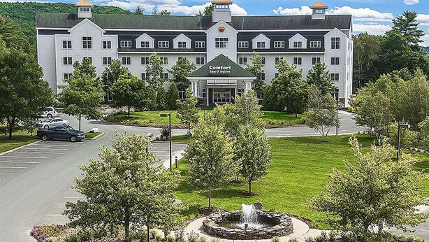 A large, white building with a central entrance labeled "Comfort Inn of Maine." - Comfort Inn & Suites Near Burke Mountain (St. Johnsbury)