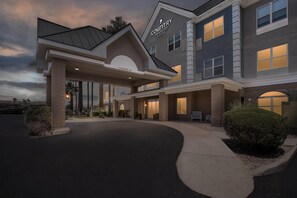 A hotel with a covered entrance, a sign reading 'Clearance 19th,' and a sign for 'Country Inns & Suites by Marriott.' - Country Inn & Suites by Radisson, Tucson Airport, AZ (Tucson)