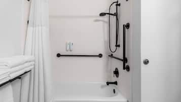 Un baño con bañera, toallero, barra de cortina de ducha y baranda.