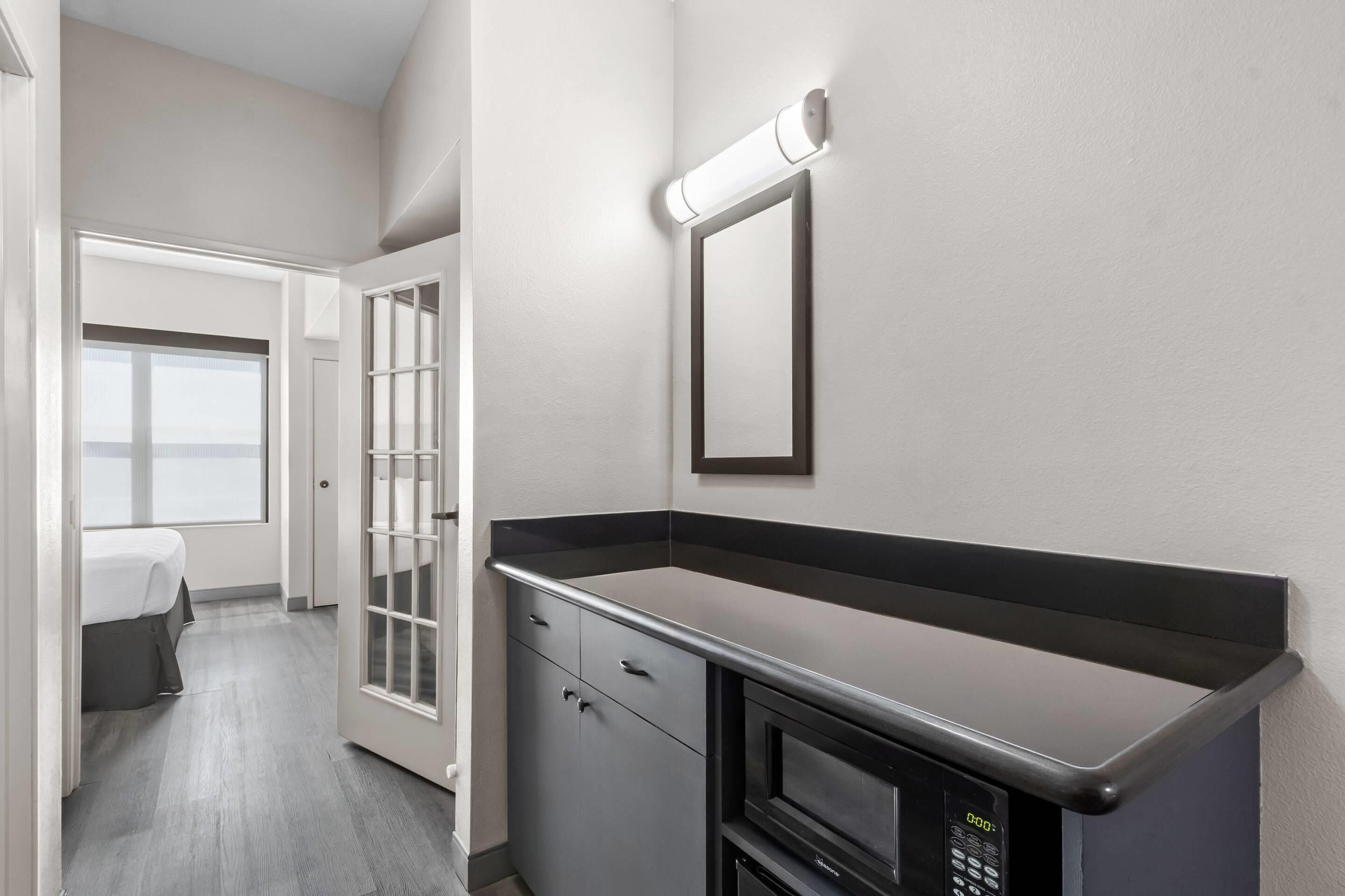 Una habitación de hotel con kitchenette, una cama y vista al cielo.