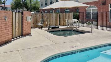 Una piscina al aire libre, sillones reclinables de piscina