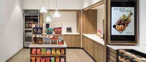 Exhibición de aperitivos con papas fritas variadas y un refrigerador de bebidas al fondo.