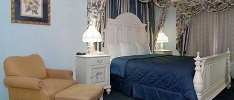 A bedroom with a bed, a nightstand, a chair, and a picture on the wall.