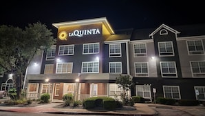 A multi-story hotel with a prominent 'La Quinta' sign, featuring a sun symbol. - La Quinta Inn & Suites by Wyndham Rockwall (Rockwall)