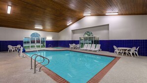 An indoor swimming pool with a wooden ceiling, blue-tiled walls, and white lounge chairs. - La Quinta Inn & Suites by Wyndham Rockwall (Rockwall)