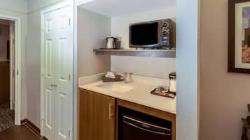 A compact kitchen with a microwave, sink, and dishwasher.