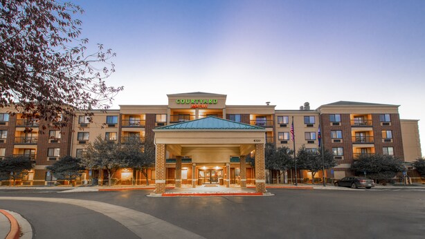 Ein Courtyard Marriott Hotel mit Ziegelaußenwand, mehreren Balkonen und einem zentralen Eingang.