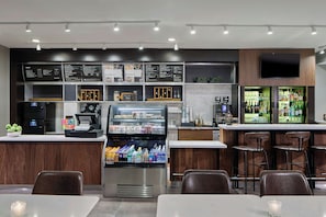 A modern cafe with a coffee machine, a refrigerated drink display, and a menu board. - Courtyard by Marriott Providence Downtown (Providence)