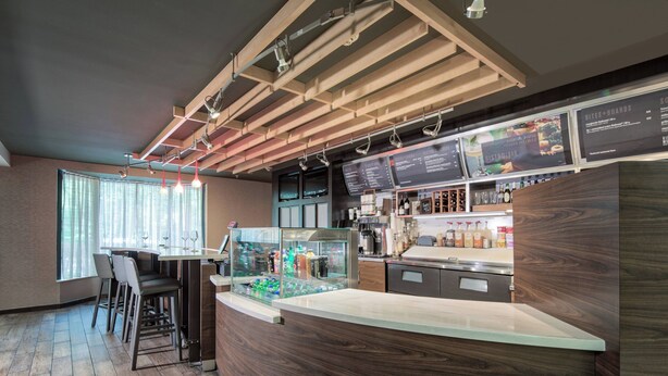 Een modern restaurantinterieur met een houten toonbank, bar en zithoek.