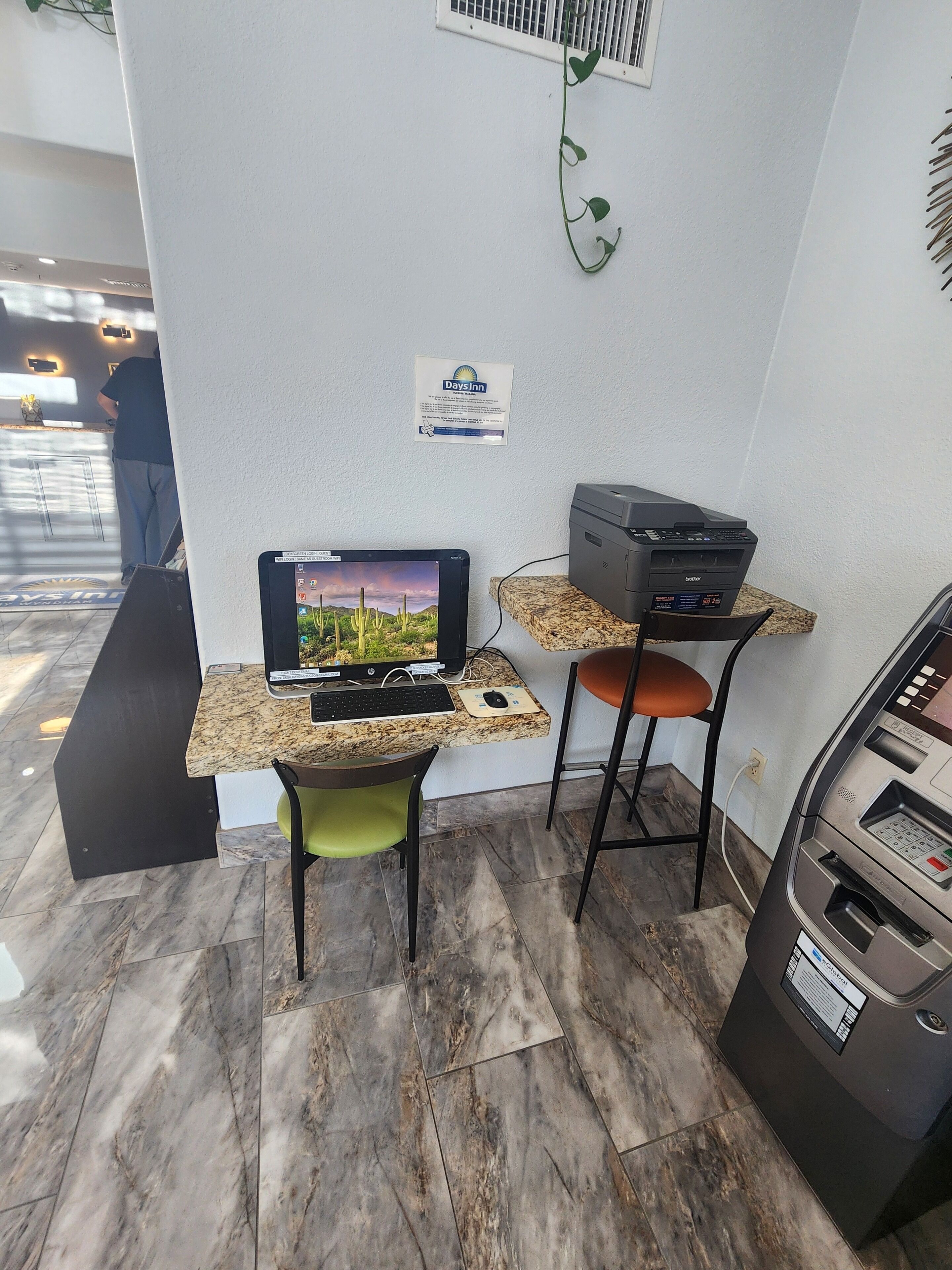 Una mesa de recepción con computadora, impresora y cajero automático.