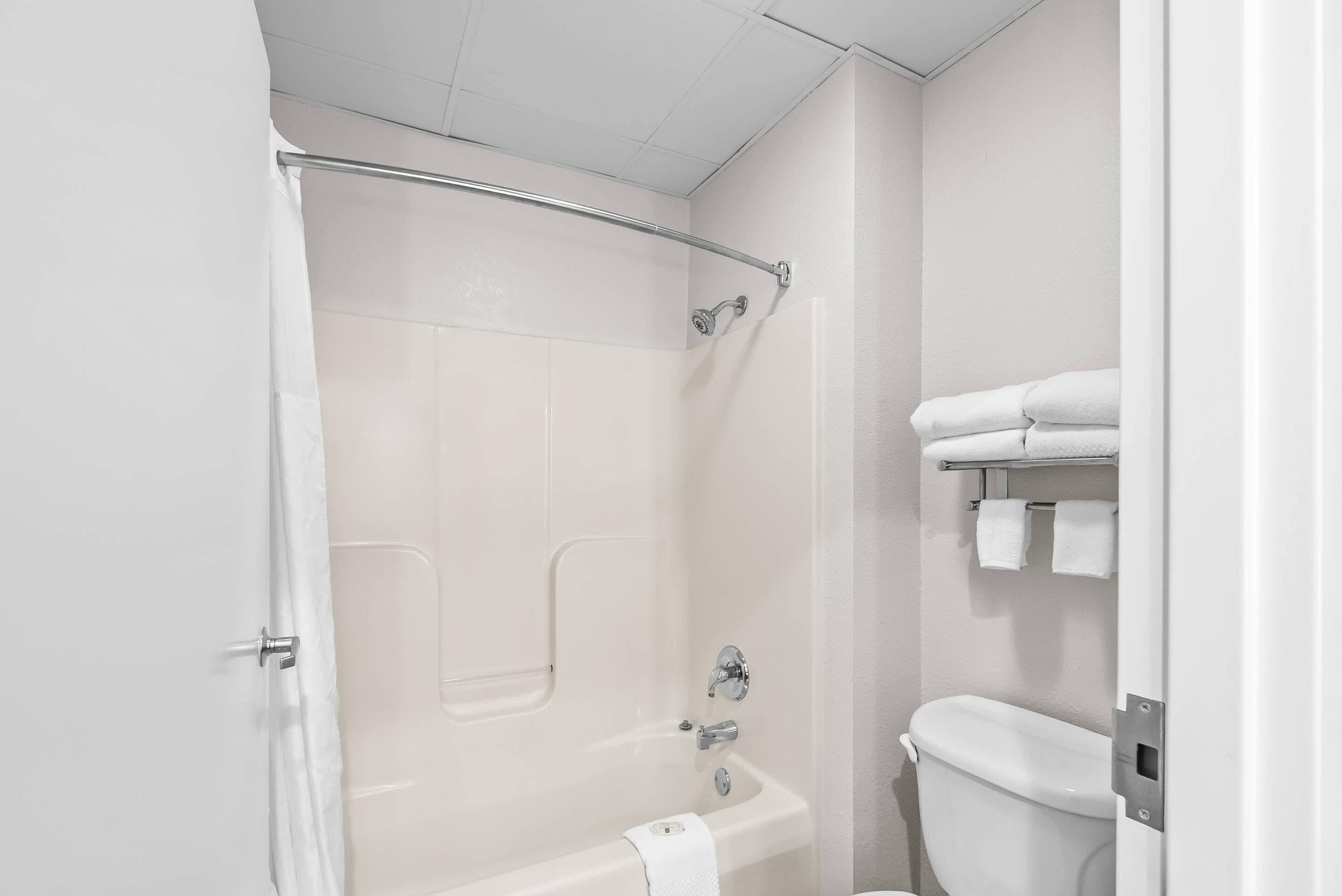 A bathroom with a bathtub, toilet, and towel rack.