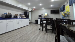 A restaurant with a counter, seating area, and a TV mounted on the wall. - OYO Hampton South Carolina Hwy 278 (Hampton)