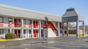 Ein Motel mit einer zentralen Treppe, mehreren Balkonen und einem Parkplatz.