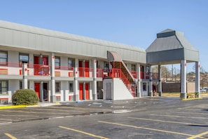 A motel with a central staircase, multiple balconies, and a parking lot. - Hotel Pineville LA Hwy 165 (Pineville)
