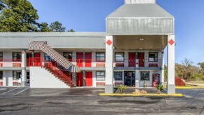 Ein Motel mit einer zentralen Treppe, mehreren Balkonen und einer überdachten Eingangszone.