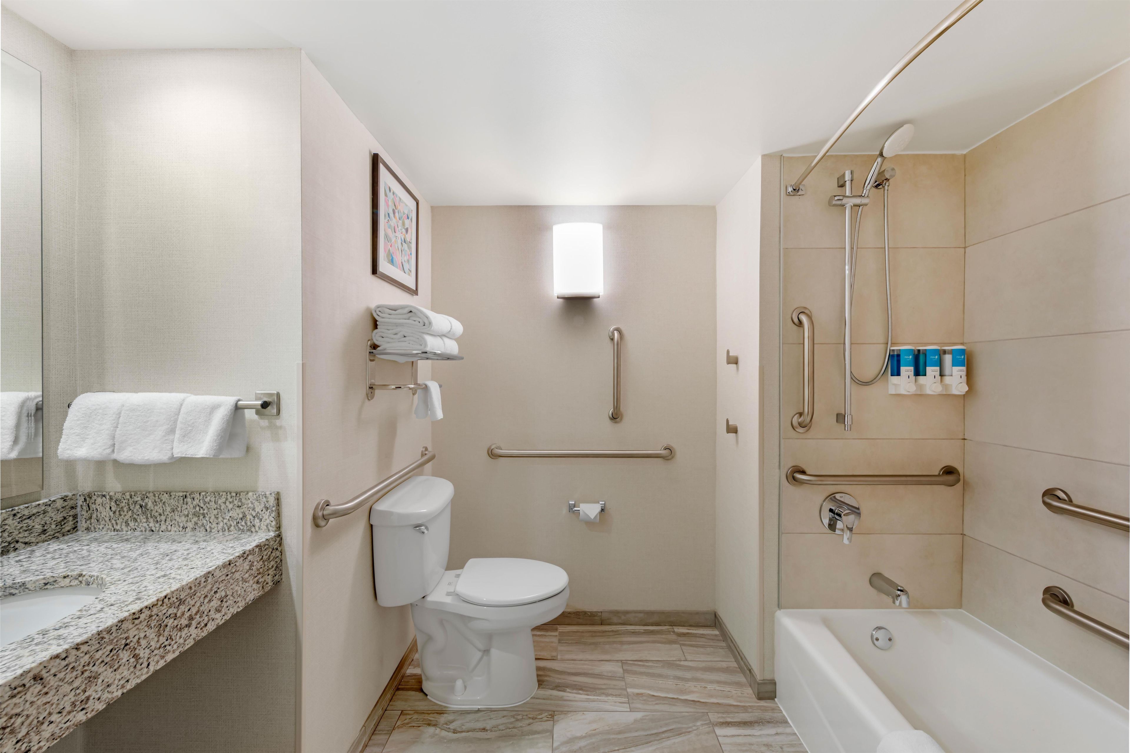 Ein modernes Badezimmer mit Toilette, Waschbecken, Dusche und Badewanne.