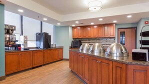 Una cocina moderna con armarios de madera, encimeras de granito y electrodomésticos de acero inoxidable.