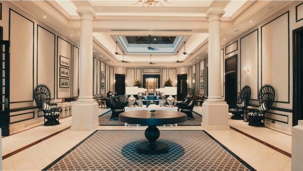 A spacious lobby with a central round table, seating arrangements, and a skylight. - The Strand Yangon (Yangon)