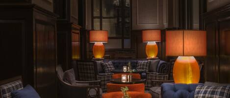 A cozy lounge area with plush seating, ambient lighting, and a classic interior design.