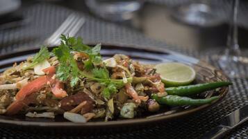 A plate of food with various ingredients, garnished with herbs and a lime wedge.