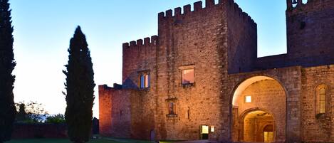 A historic stone castle with a large arched entrance and a bell tower.