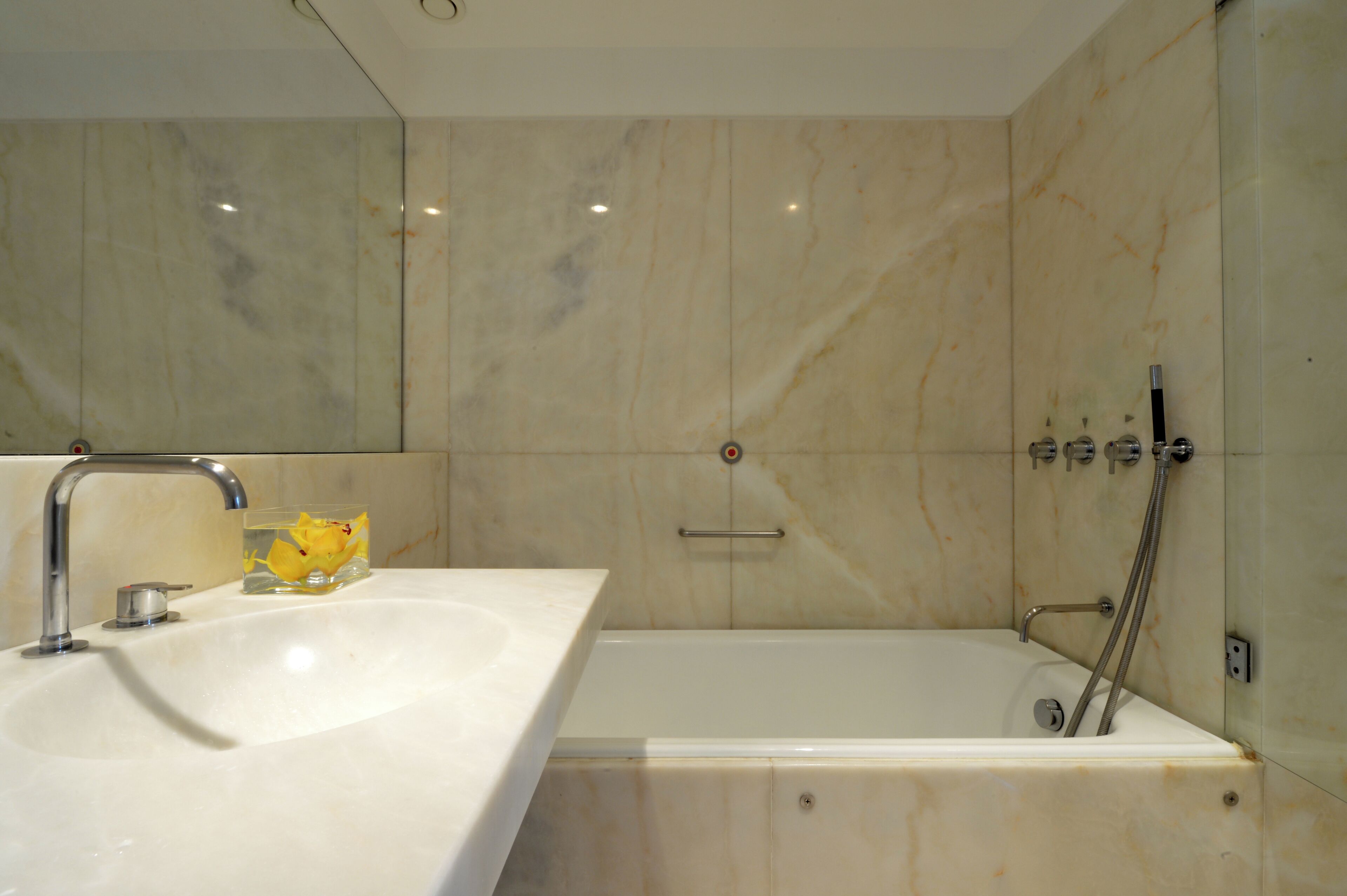 Ein modernes Badezimmer mit Marmorwaschbecken, einer Badewanne und einer Dusche.