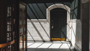 Un pasillo estrecho con una puerta marcada '309-312' y un muro de baldosas.