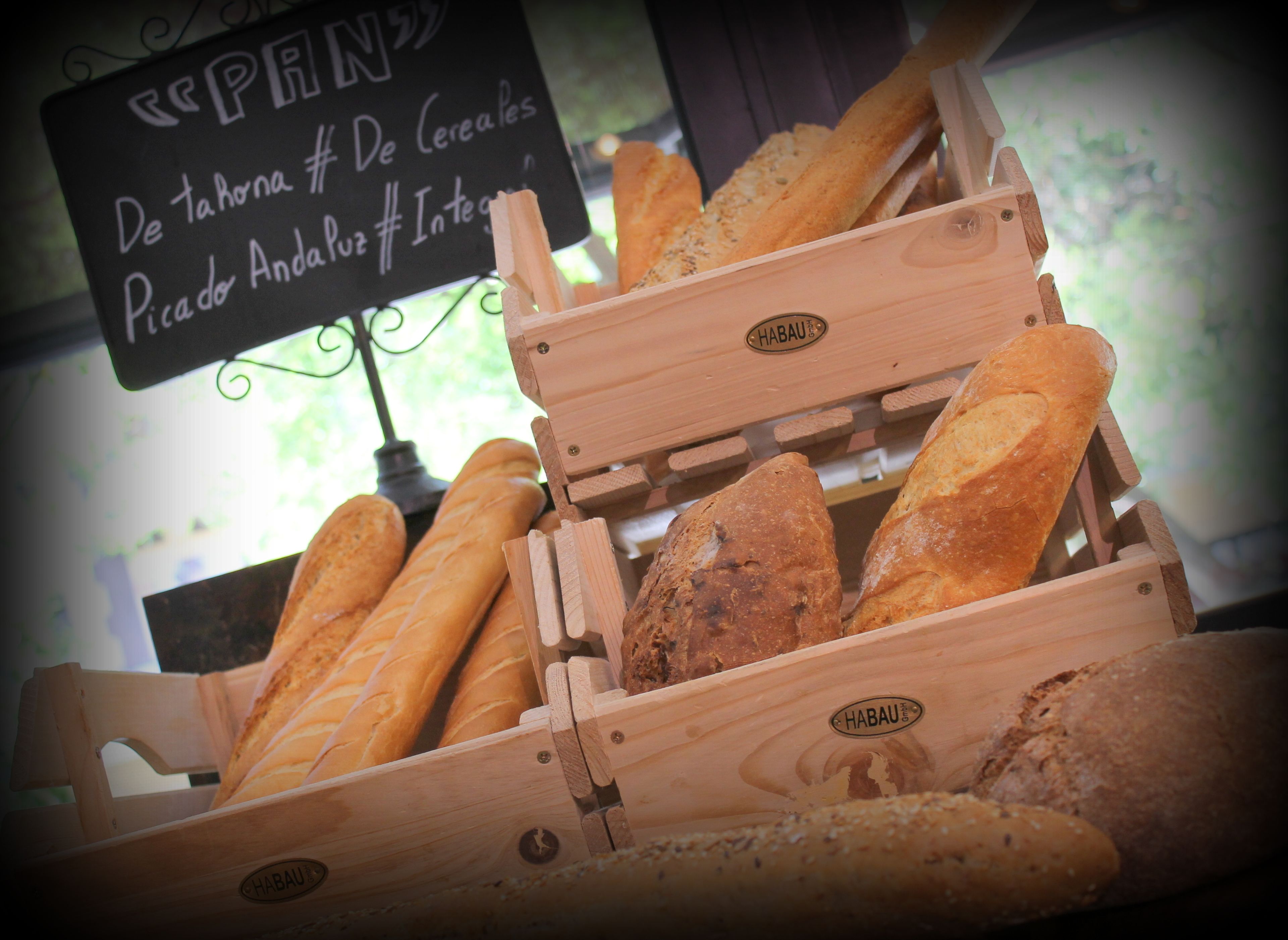 A wooden bread display with a sign in the background.