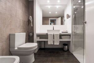 Une salle de bain moderne équipée de toilettes, d’un lavabo et d’une douche.