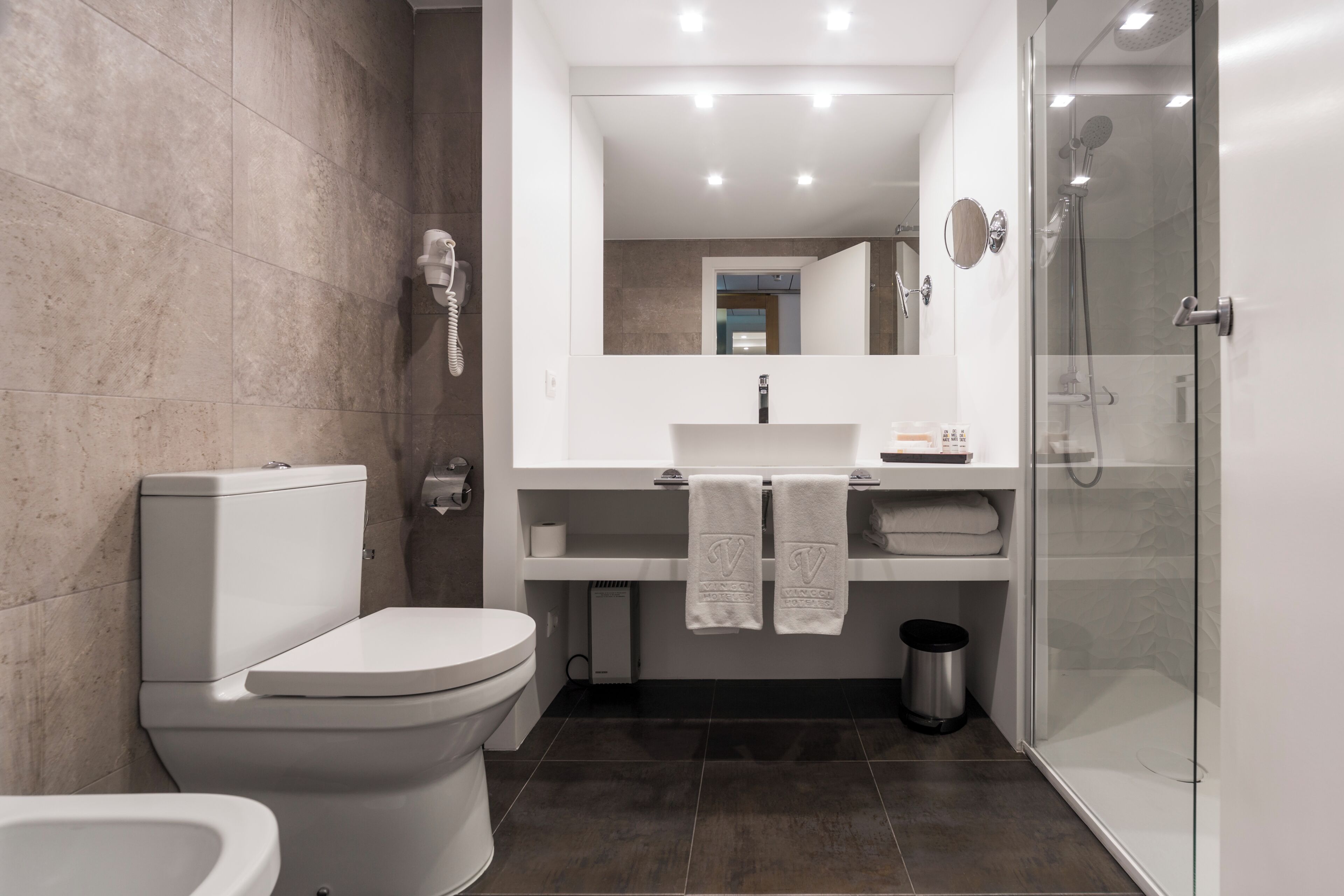 Une salle de bain moderne équipée de toilettes, d ’un lavabo et d’une douche.
