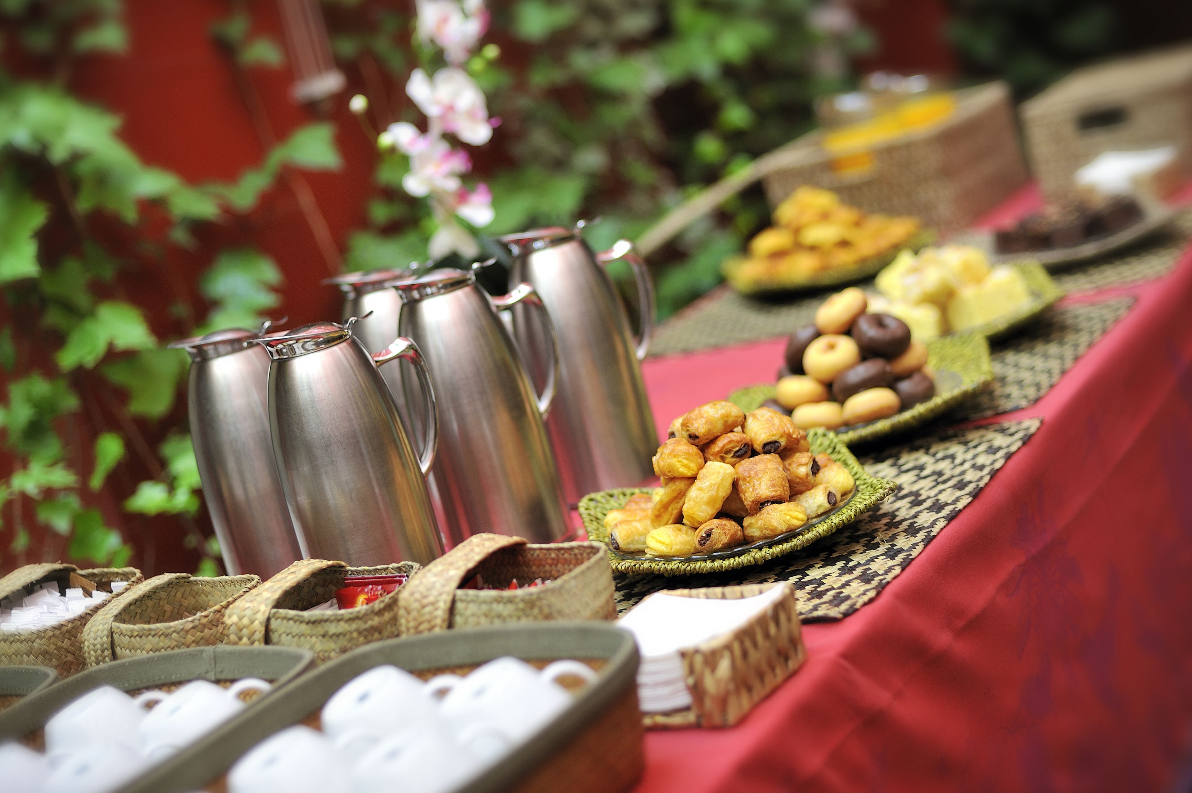Una mesa con diversos alimentos y vasos térmicos de acero inoxidable.
