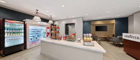 A reception area with a counter, vending machines, and a seating area.