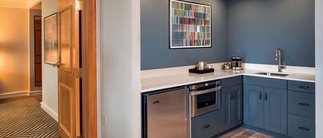Una cocina moderna con lavavajillas integrado, electrodomésticos de acero inoxidable y una pared de acento azul.