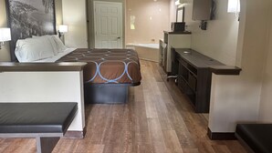 A hotel room with a bed, a desk, a chair, a TV, and a ceiling fan. - Super 8 by Wyndham Moss Point (Moss Point)
