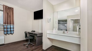 A hotel room with a desk, chair, and a large mirror. - Super 8 by Wyndham Moss Point (Moss Point)