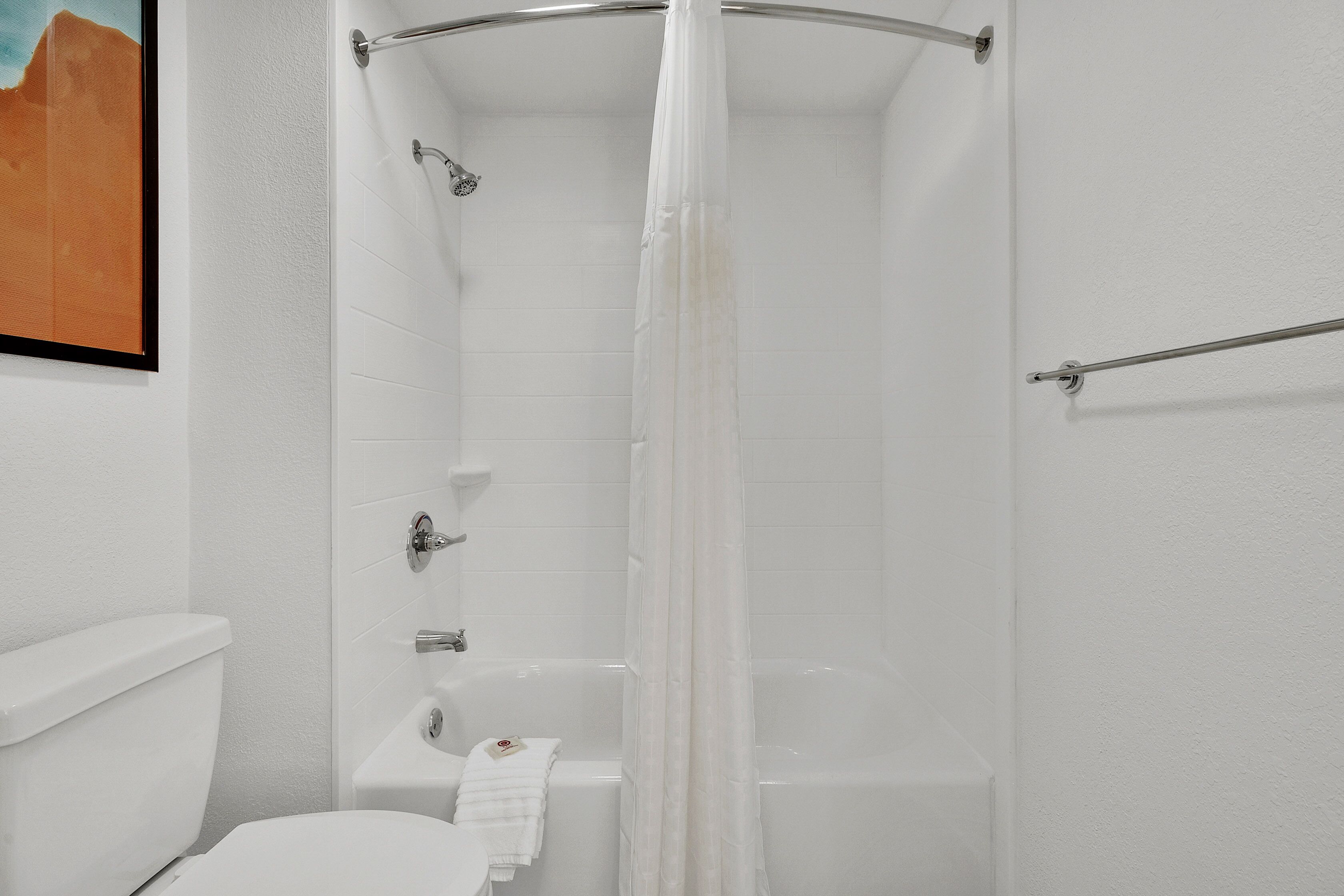 A bathroom with a shower, toilet, and bathtub.