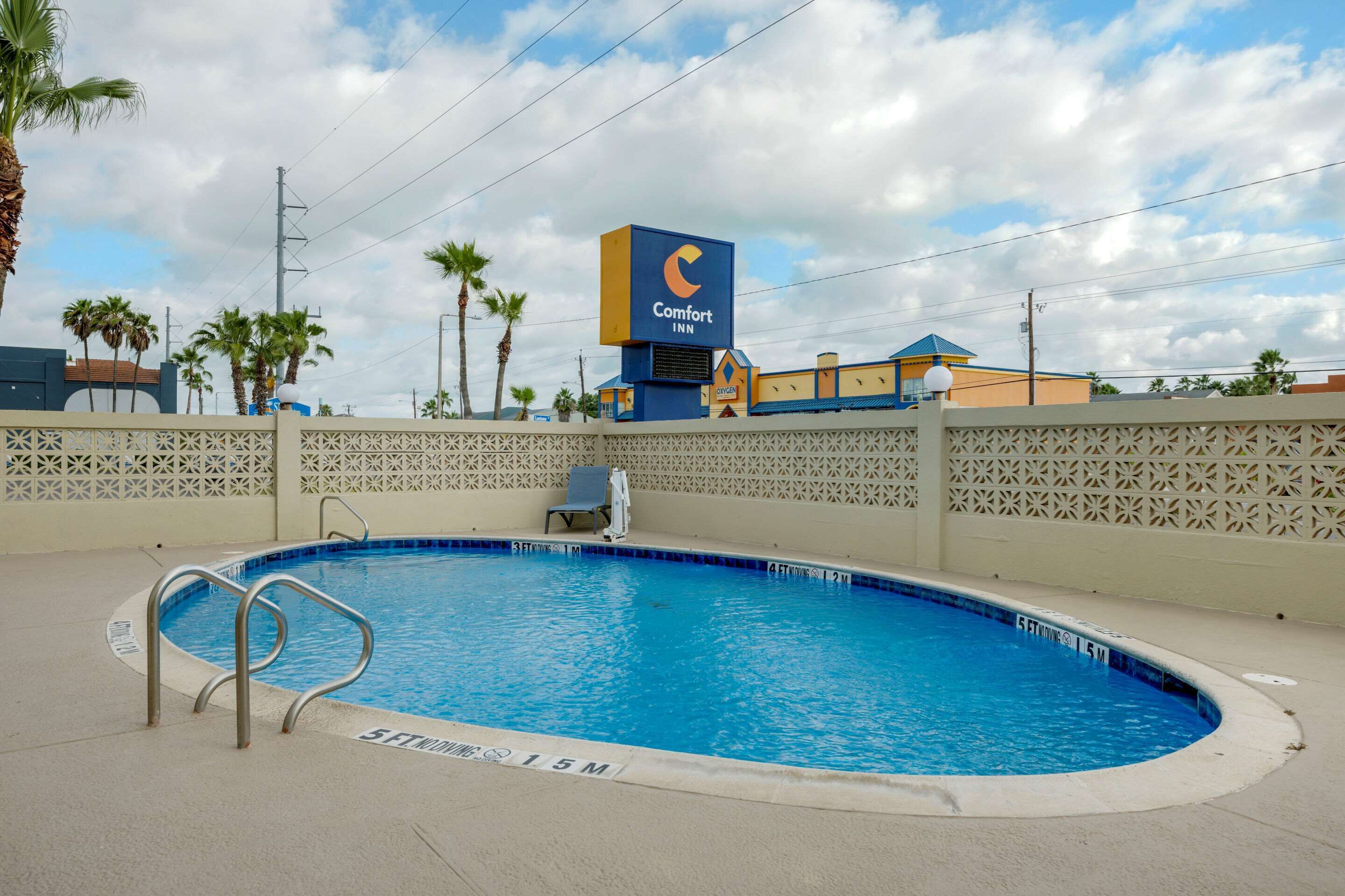 Ein Swimmingpool mit einem Comfort Inn Schild im Hintergrund.
