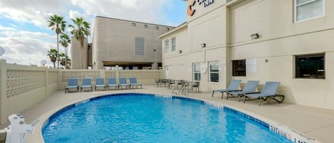 Ett poolområde med solstolar och en skylt för hotellkedjan Comfort Inn.