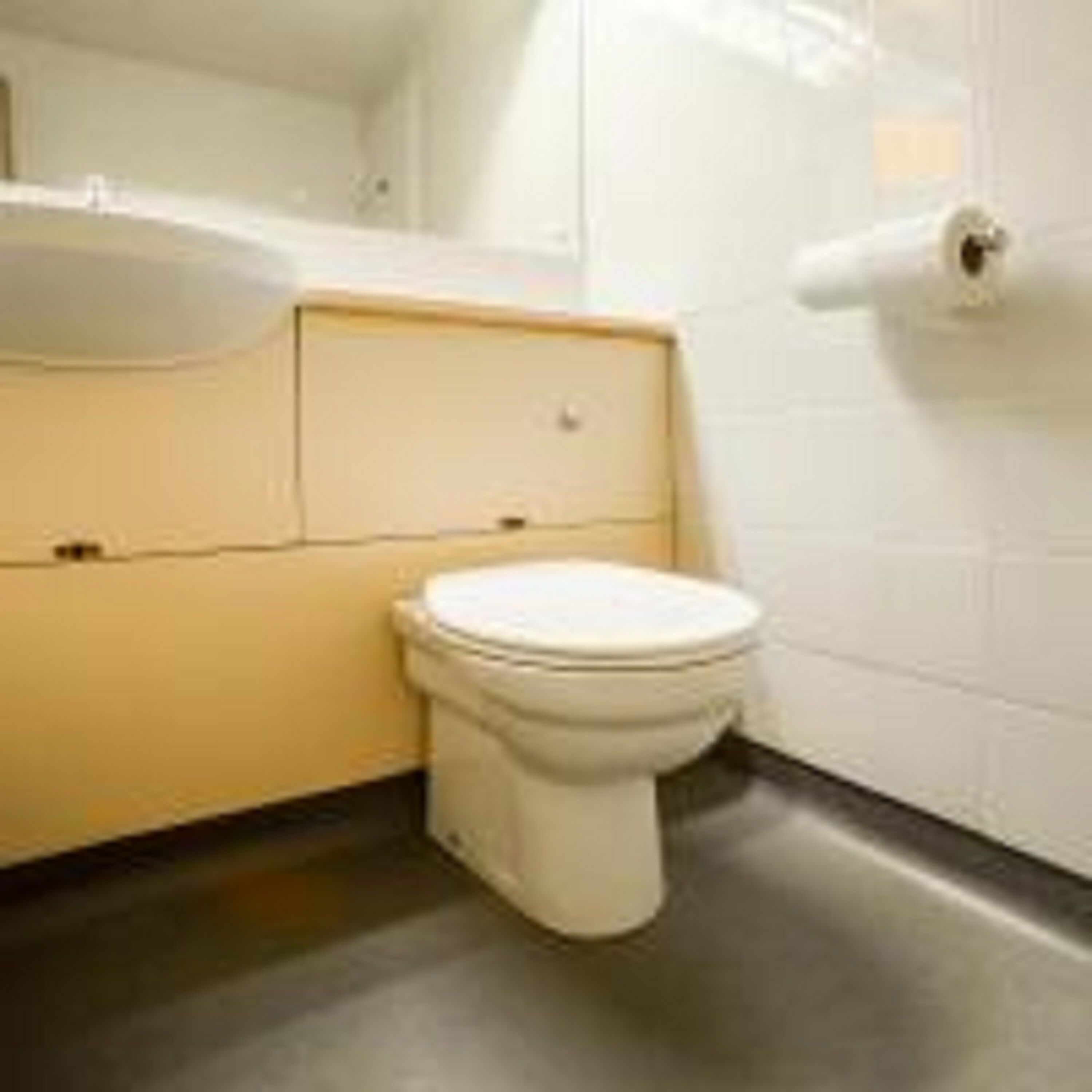 Un baño pequeño y funcional con inodoro, lavamanos y espejo.