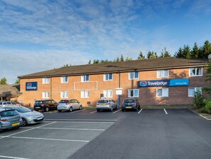 A Travelodge hotel with a parking lot and several cars parked in front. - Travelodge Stirling M80 (Stirling)