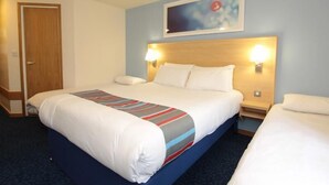 Ein Hotelzimmer mit einem großen Bett, zwei Nachttischen und einem Kopfteil mit Wandleuchten.