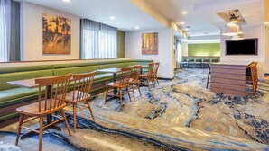 A restaurant with green cushioned booths, wooden chairs, and a patterned floor. - Fairfield Inn By Marriott Indianapolis Northwest (Indianapolis)