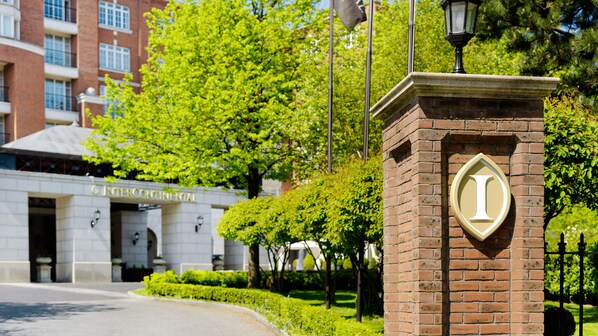 Welcome to the entrance of the Intercontinental, surrounded by beautifully landscaped gardens and a striking brick structure.